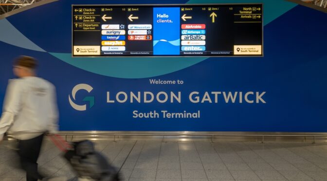 man walking into Gatwick airport with bag