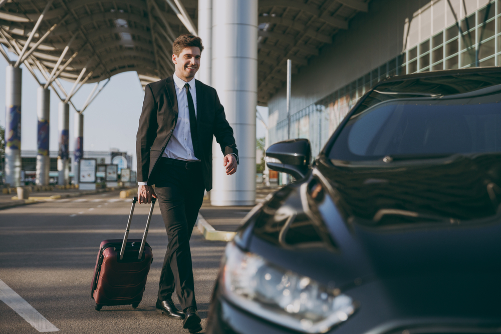 Man leaving taxi with his bag