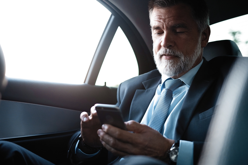 Successful,Businessman,Working,On,Phone,In,Car.,Mature,Smiling,Business